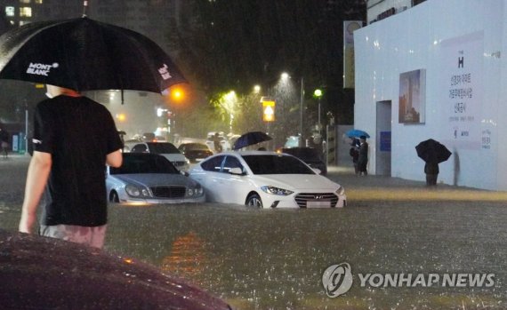 2022년 8월 9일 서울 강남구 대치동 은마아파트 부근. 쏟아진 폭우로 도로와 인도가 물에 잠기면서 차량이 침수되고 시민이 통행에 어려움을 겪었다. ⓒ사진 2022.08.09 연합뉴스