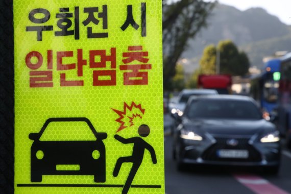 '교차로 우회전 통행법' 계도기간 마지막 날, 우회전 시 일단멈춤 안내문이 부착된 모습. ⓒ 뉴스1. 2022년 10월