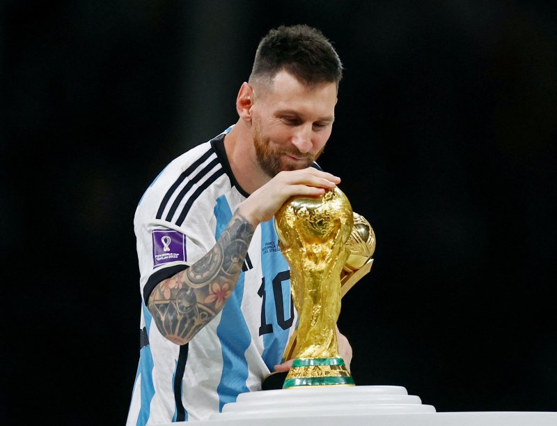 아르헨티나의 주장 '리오넬 메시'가 2022 카타르 월드컵 '골든 볼 어워드'를 수상하고 우승 트로피에 입을 맞추려는 모습 ⓒ로이터=뉴스1. 2022년 12월