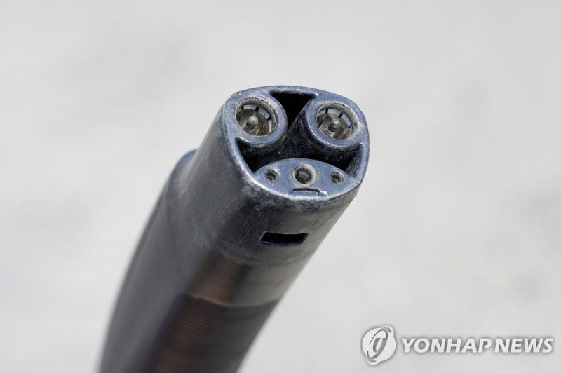북미 표준 충전 방식(NACS)를 적용한 테슬라의 충전기. 2024년 부터 포드, GM, 볼보, 리비안의 전기차도 어댑터만 있다면 슈퍼차저에서 충전할 수 있다. 2025년부터는 출시 차량에 NACS 규격을 적용해 어댑터 없이도 슈퍼차저의 충전기를 사용할 수 있다. ⓒ사진 AP 연합뉴스