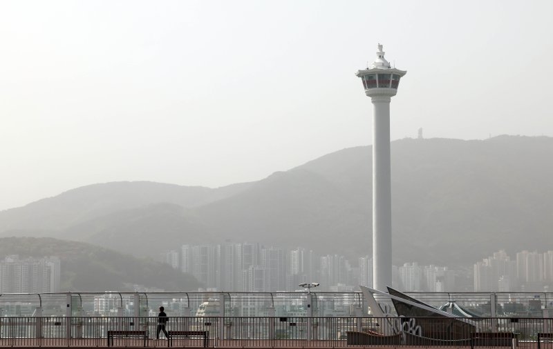 황사의 유입으로 부산 16개 구·군 모든 지역에 이틀째 '미세먼지(PM-10) 경보' 등이 발령된 18일 부산 중구 롯데백화점 광복점 옥상 전망대를 찾은 시민이 뿌옇게 변한 도심을 바라보고 있다. ⓒ사진 2024년 4월 18일 뉴시스